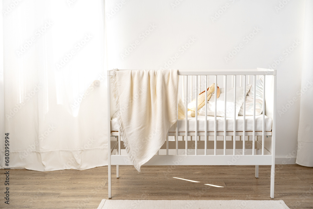 Muslin baby blanket hanging on child's bed in nursing room Muslin baby blanket hanging on child's bed in nursing room