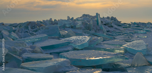 Huge blocks of ice on the shore of a lake on a winter evening photo