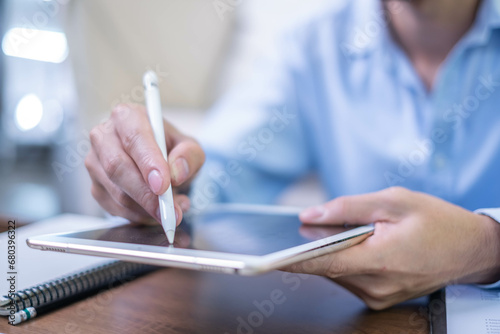 Closeup hand pen writing black screen background digital tablet technology work office business person, online internet job businessman using planning stylus electronic device note document photo