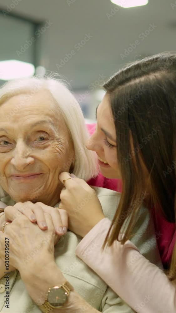Smiling nurse kissing and embracing a senior woman in geriatric Smiling nurse kissing and embracing a senior woman in geriatric