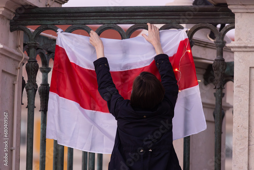 Fototapeta Woman with white red white flag of Belarus resistance - visit of opposition in L