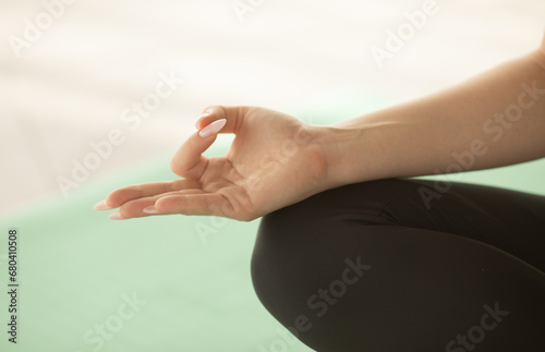 Close up of hands young woman working out on fitness mat, doing lotus yoga pose at the gym. Yoga exercise, relax and meditating, copy space. 