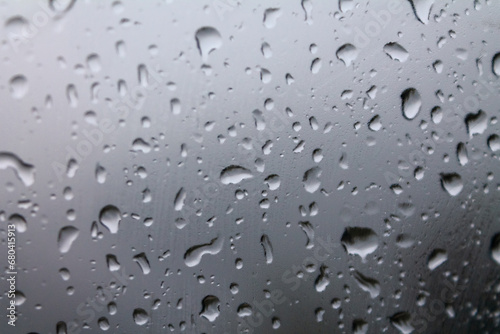 Drops of water on glass on a cold background, rainy weather high humidity, worsening weather forecast selective focus