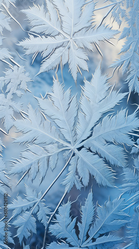 Frosty natural pattern on window glass. Frost pattern on the window. Snowflakes on blue background close-up.