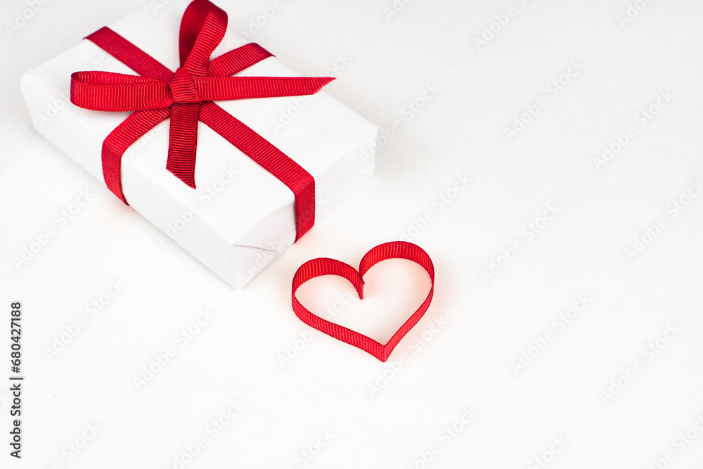 White boxes with red ribbons and decorative heart isolated on white background. Greeting card White boxes with red ribbons and decorative heart isolated on white background. Greeting card
