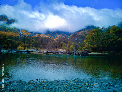Beautiful Taisho Pond at Kamikochi, Japan. The still blue waters of the pond reflect the surrounding forested mountains. photo