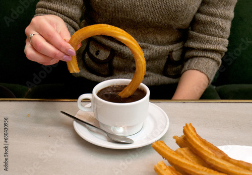 hot chocolate dipping sauce served in a cup and plate of churros, San Gines chocolateria in Madrid, Spain, Europe photo