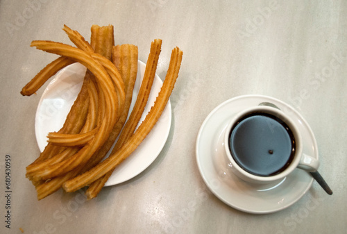 hot chocolate dipping sauce served in a cup and plate of churros, San Gines chocolateria in Madrid, Spain, Europe photo