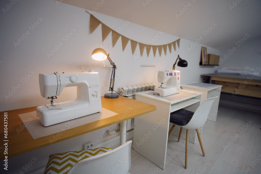 Fototapeta premium Sewing machine on table in modern sewing studio. Tailor shop