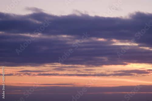 Sunset sky with red light of the setting sun. Evening clouds in the orange light of sunset rays © Андрей Журавлев