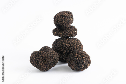 Group of Black Truffles Stacked on White Background