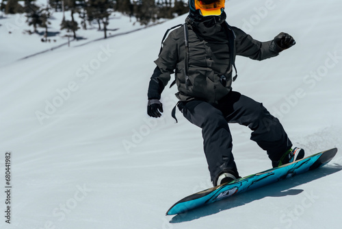 snowboarder. an athlete in a special snowboarding suit rides on the snowy slopes. winter sport concept