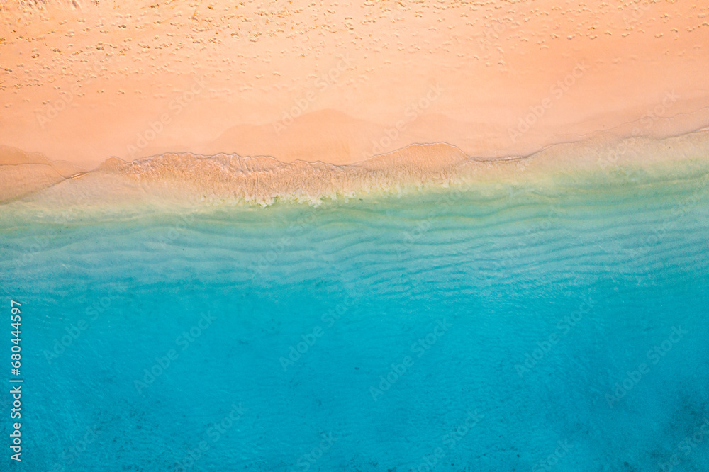 Summer seascape beautiful waves, blue sea water in sunny day. Top view from drone. Sea aerial view, amazing tropical nature background. Beautiful bright sea waves splash crash beach sand  landscape