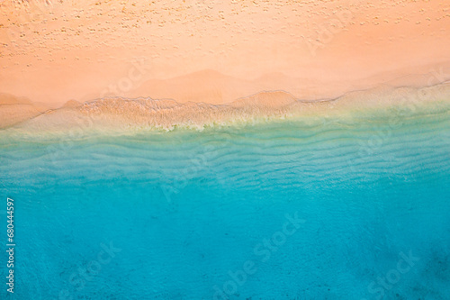 Summer seascape beautiful waves, blue sea water in sunny day. Top view from drone. Sea aerial view, amazing tropical nature background. Beautiful bright sea waves splash crash beach sand landscape