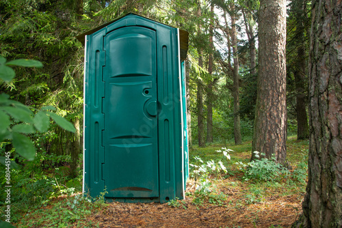 Outdoors toilet in green forest.