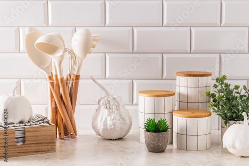 Modern kitchen background with elements of natural decor  white decorative pumpkins. Stylish jars for storage. Towel in a wooden box.