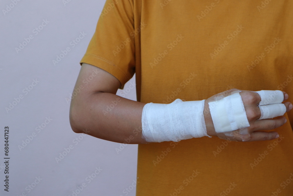 Obraz premium The woman wore a yellow shirt and had a bandage wrapped around her hand. After being injured while cooking