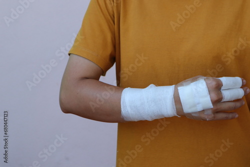 The woman wore a yellow shirt and had a bandage wrapped around her hand. After being injured while cooking