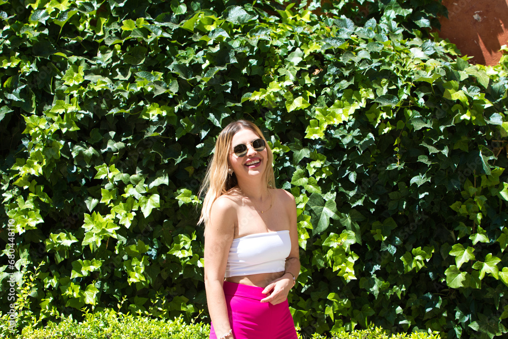 Young and beautiful brunette woman with blonde and latin hair is on holiday in seville. The woman is walking through the Jewish quarter of the Spanish city and poses for pictures making expressions. Young and beautiful brunette woman with blonde and latin hair is on holiday in seville. The woman is walking through the Jewish quarter of the Spanish city and poses for pictures making expressions.