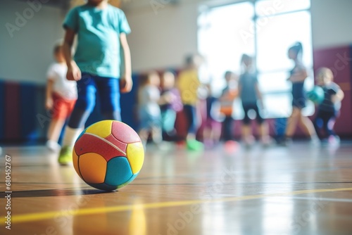 A group of children playing with a ball in a gym. Suitable for sports and recreational activities photo