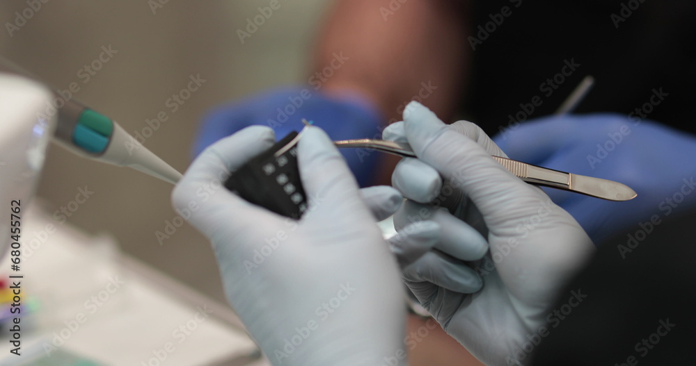 Doctor's hands with a working tool. Preparation and process of dental treatment. Dental instrument in the office of a modern dentist. Close-up in 4K, UHD