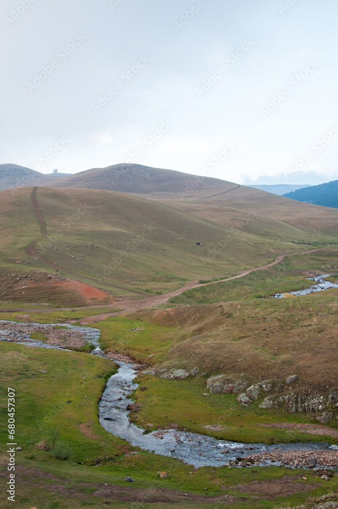 Landscape evening view of Assy plateau with its grass-covered slopes, the Republic of Kazakhstan, vertical shot