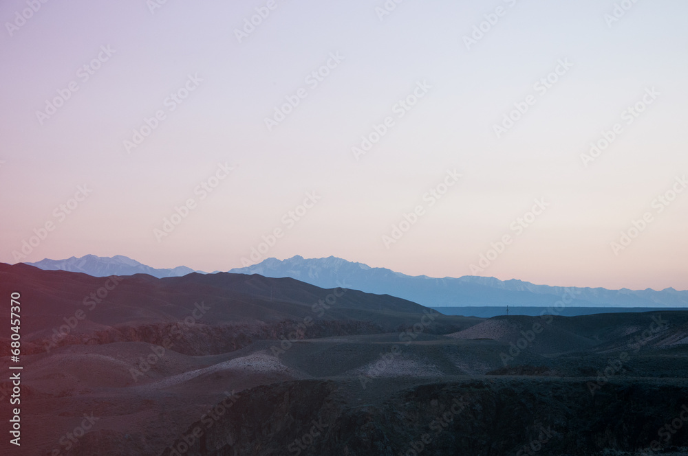 Picturesque wilderness of Kazakhstan with silhouettes of hills and mountains at sunset Picturesque wilderness of Kazakhstan with silhouettes of hills and mountains at sunset