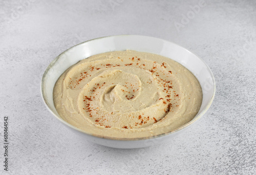 Classic hummus in a white plate on a gray background. Arabic, Turkish cuisine
