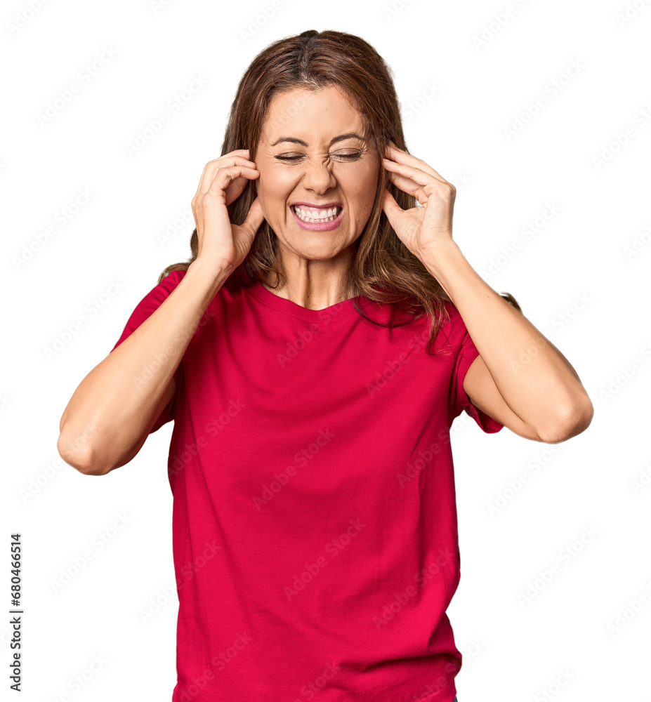 Middle-aged woman portrait in studio setting covering ears with hands. Middle-aged woman portrait in studio setting covering ears with hands.