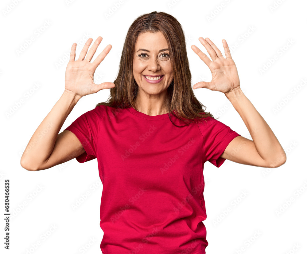 Middle-aged woman portrait in studio setting showing number ten with hands. Middle-aged woman portrait in studio setting showing number ten with hands.