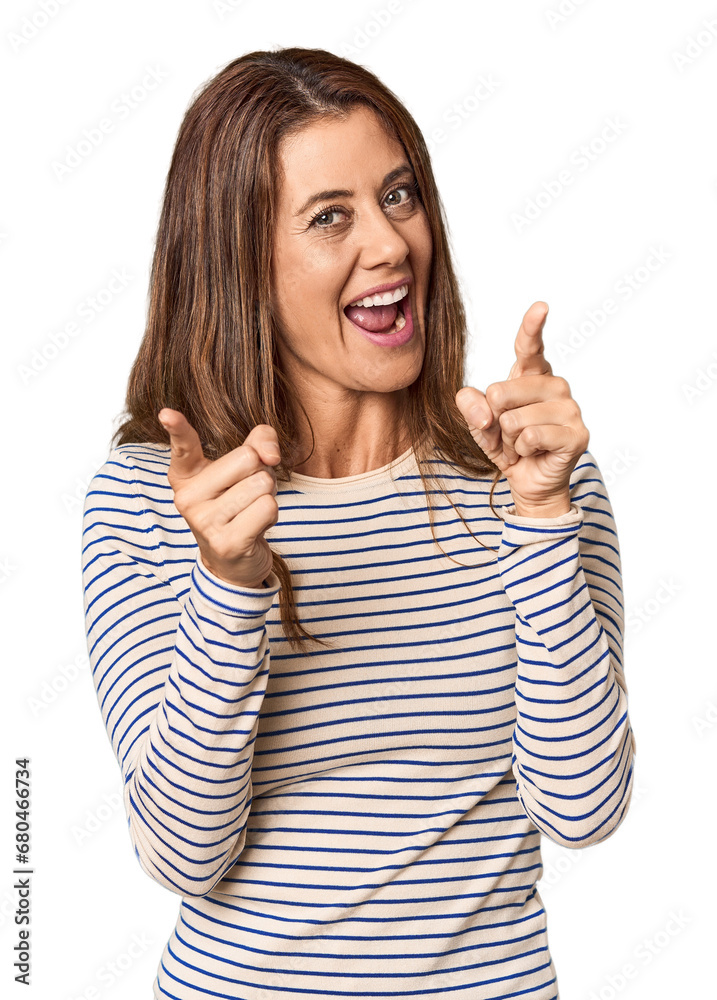 Middle-aged woman portrait in studio setting pointing to front with fingers. Middle-aged woman portrait in studio setting pointing to front with fingers.