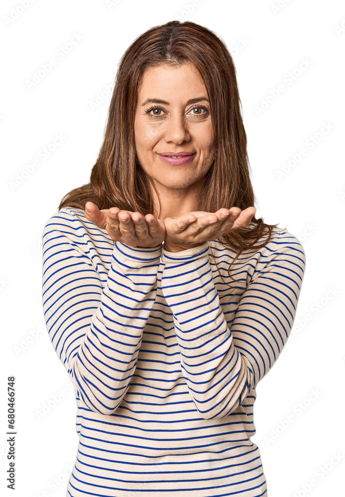 Middle-aged woman portrait in studio setting holding something with palms, offering to camera. Middle-aged woman portrait in studio setting holding something with palms, offering to camera.
