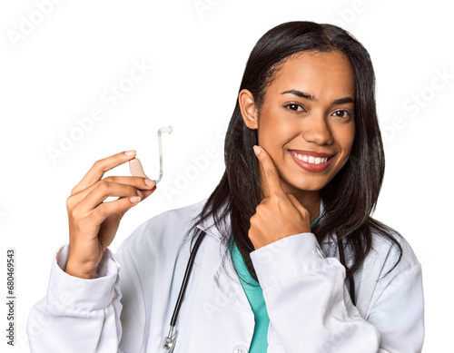 Young Filipina doctor holding hearing amplifier in studio