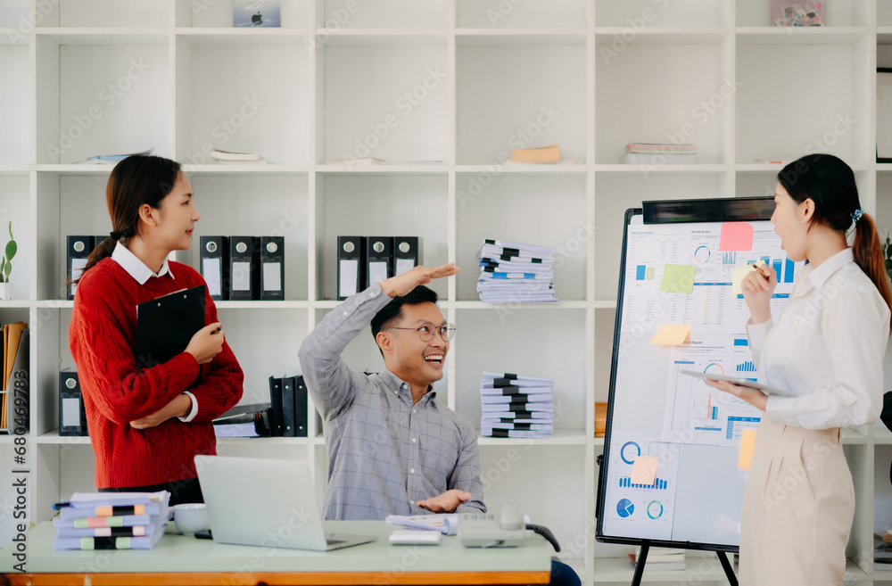 Obraz premium Office colleagues have a casual discussion. During a meeting in a conference room, a group of Asian business teem sit in the conference room new startup project..