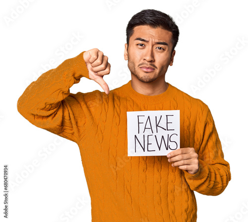 Schilderij op canvas Chinese man showing fake news sign with skeptical expression in studio