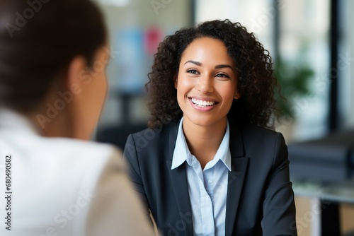 A radiant business professional smiles during a meeting, her demeanor approachable and engaging