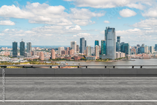 Empty urban asphalt road exterior with city buildings background. New modern highway concrete construction. Concept of way to success. Transportation logistic industry fast delivery. New York. USA.