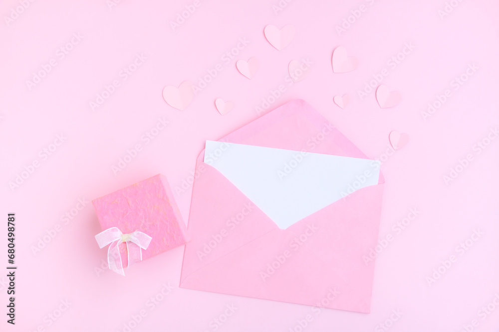 Pink envelope with white greeting card, Pink gift box and pink heart shape papercut on pink background, Love and Valentine concept Pink envelope with white greeting card, Pink gift box and pink heart shape papercut on pink background, Love and Valentine concept