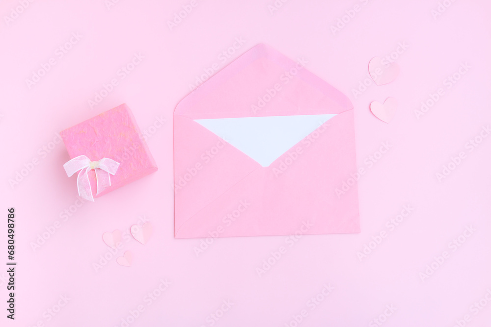 Pink envelope with white greeting card, Pink gift box and pink heart shape papercut on pink background, Love and Valentine concept