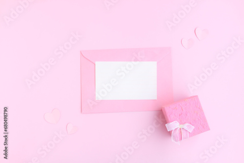 Pink envelope with white greeting card, Pink gift box and pink heart shape papercut on pink background, Love and Valentine concept