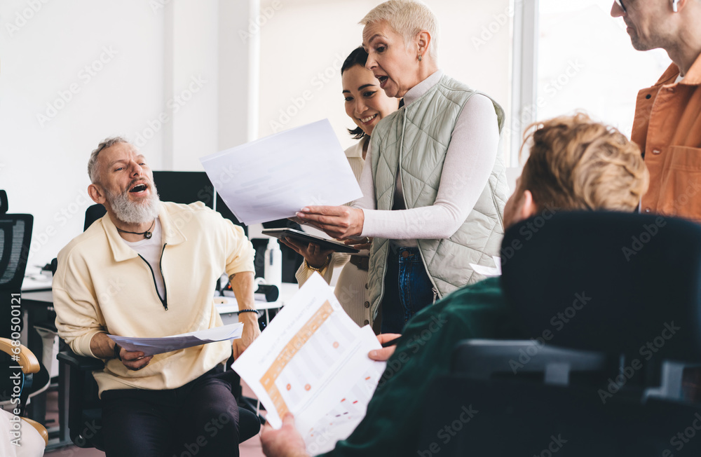 Positive diverse colleagues working with documents in office Positive diverse colleagues working with documents in office