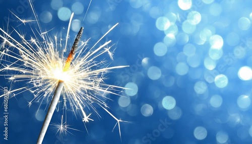 Sparkler burning bright with shiny sparks. Dark blue festive background. Happy New Year concept.