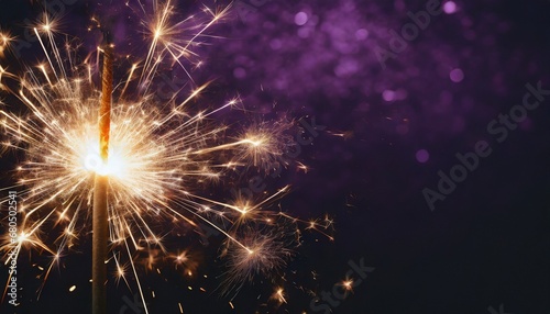 Sparkler burning bright with shiny sparks. Dark purple festive background. Happy New Year concept.