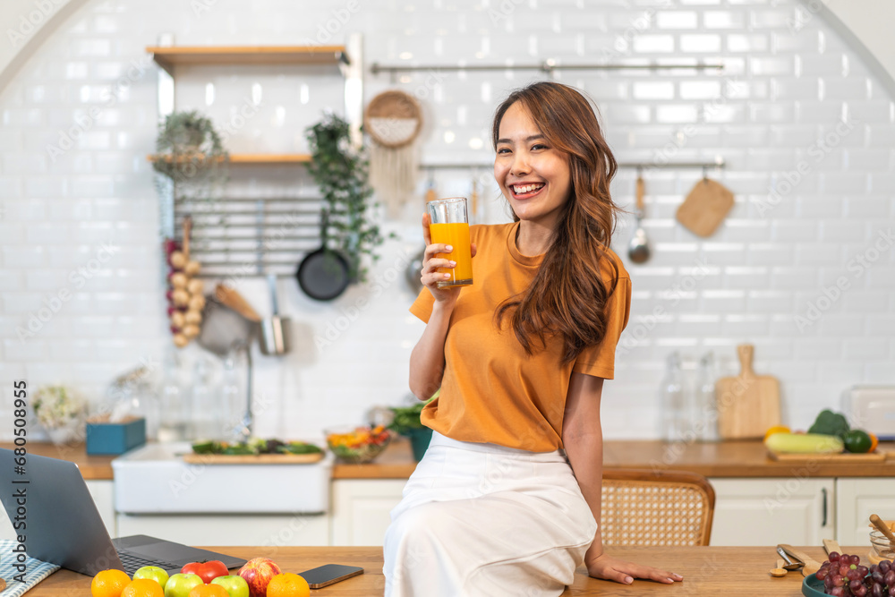 Portrait of beauty healthy asian woman making orange fruit smoothie with blender.girl preparing cooking detox cleanse with fresh orange juice in kitchen at home.health, vitamin c, diet, healthy drink