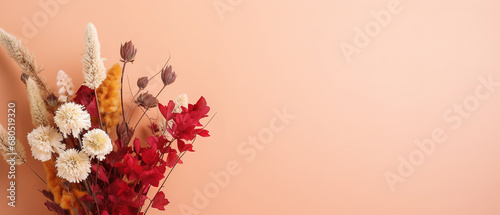 Minimalistic light background with a bouquet of dried colorful flowers on a light red wall. Beautiful background for presentation with with smooth floor. 