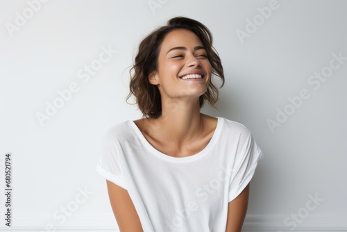 Portrait of a blissful woman in her 30s dressed in a casual t-shirt against a white background. AI Generation © CogniLens