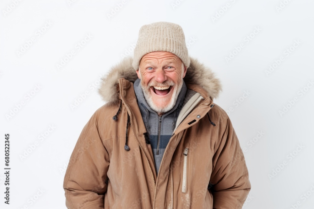 Fototapeta premium Portrait of a joyful man in his 60s wearing a warm parka against a white background. AI Generation