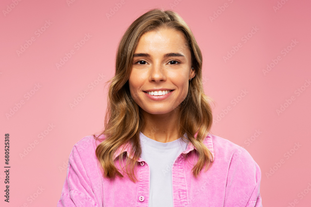 Portrait of smiling attractive woman wearing stylish casual shirt looking at camera standing isolated on pink background. Advertisement concept Portrait of smiling attractive woman wearing stylish casual shirt looking at camera standing isolated on pink background. Advertisement concept