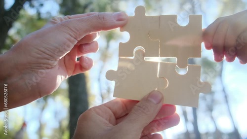 Hands of individuals across various age groups coming together to piece a puzzle, embodying the essence of teamwork, cooperation, and effective problem-solving. Witness the power of collaboration.