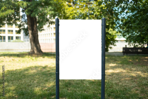 Blank mock up of vertical street poster billboard on city park background. High quality photo